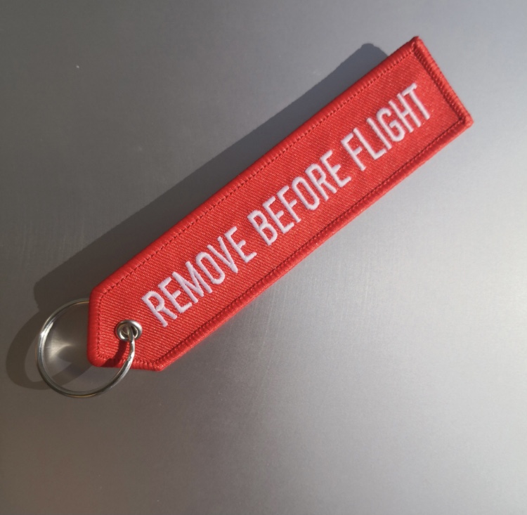 Брелок  Remove Before Flight светящийся  в темноте